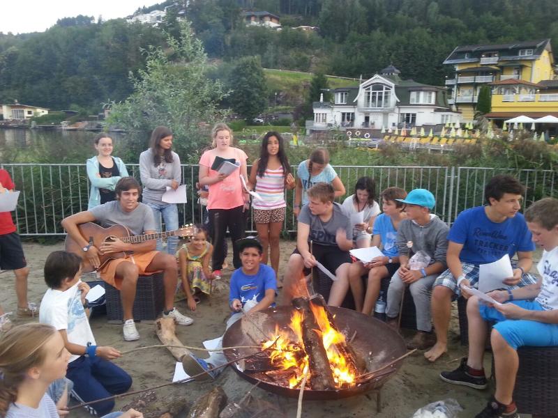 Die Teilnehmer der Sprachreise Niederlande sitzen am Lagerfeuer und machen Musik