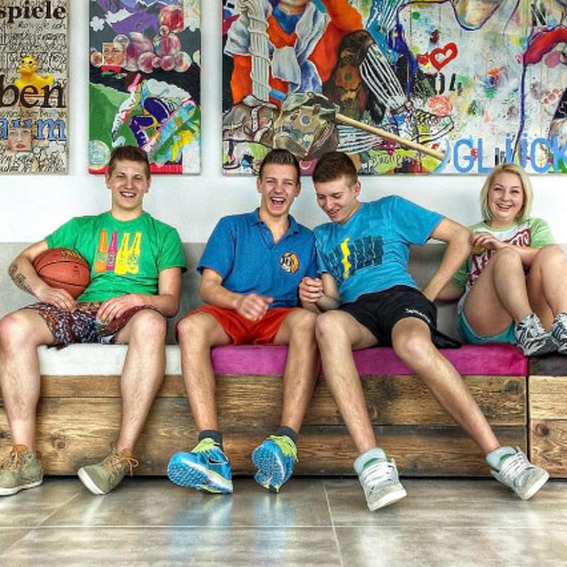 Vier Jugendliche von den Sprachreisen Österreich sitzen auf einer Bank