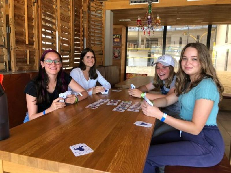Vier Mädchen sitzen am Tisch und spielen ein Kartenspiel im Lerncamp