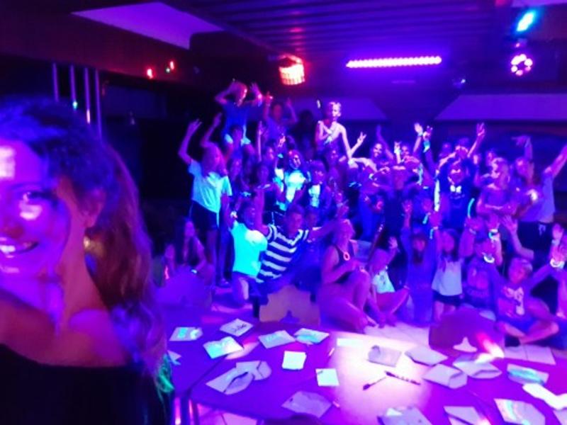 Die Teilnehmer im Lerncamp haben Spaß bei einer Party mit cooler Beleuchtung