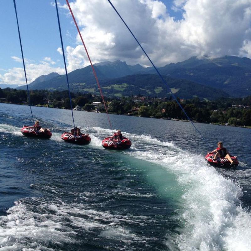 Die Kinder im Ferienlerncamp haben Spaß auf einem Wasser-Karussell