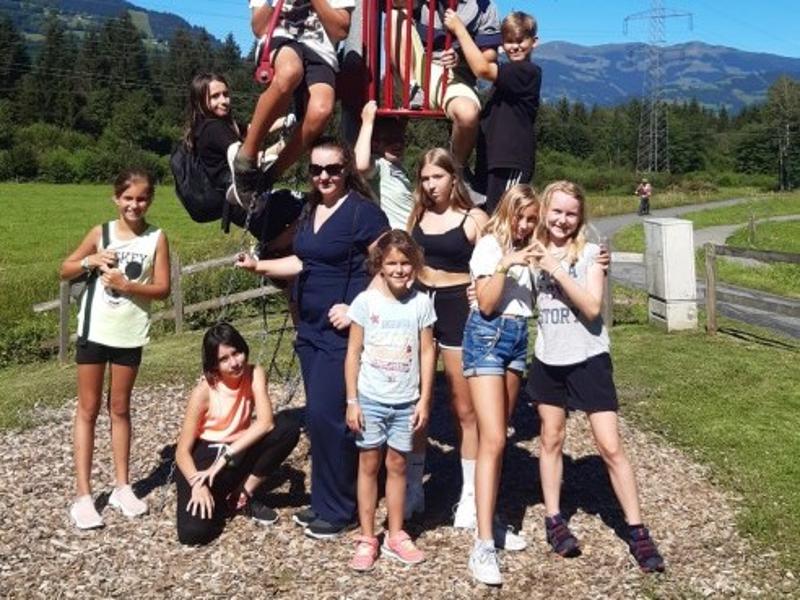 Die Kinder aus dem Ferienlerncamp posieren gemeinsam vor einem Klettergerüst