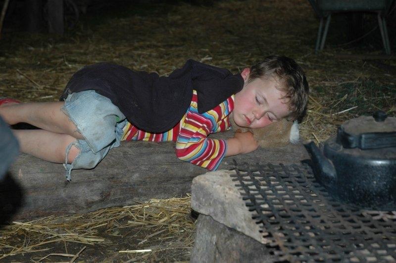 Junge schläft auf Stroh im Abenteuerurlaub Kinder Österreich