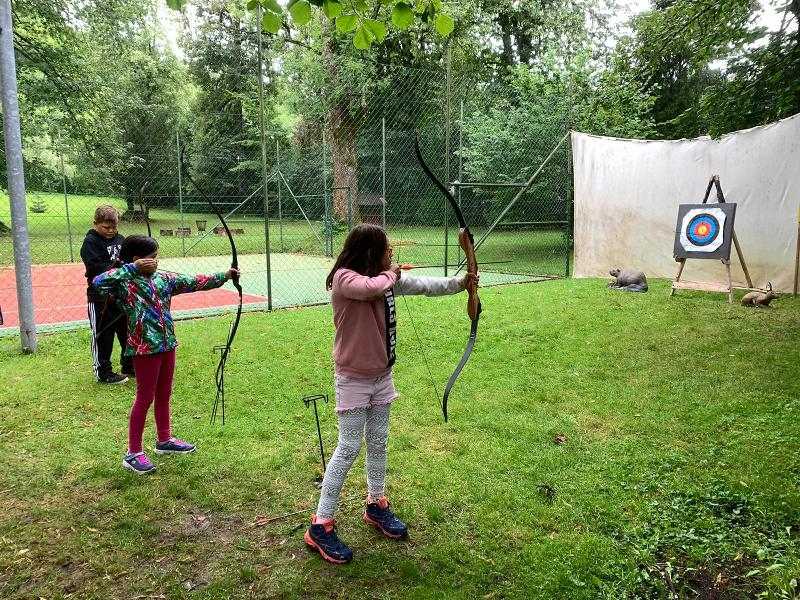 Kinder üben Bogenschießen im Englisch-Sprachcamp