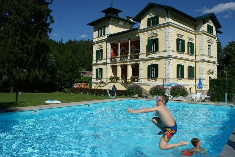 Junge springt in Pool im Sommercamp Steiermark