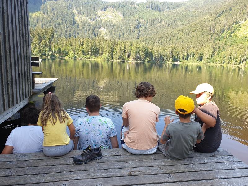 Eine Gruppe Kinder sitzt am See