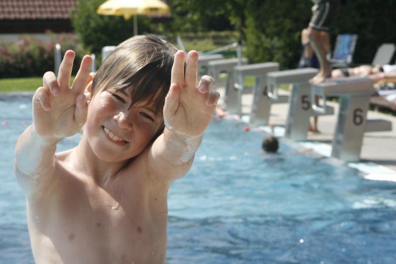 Junge posiert vor dem Pool im Sommercamp für Kinder