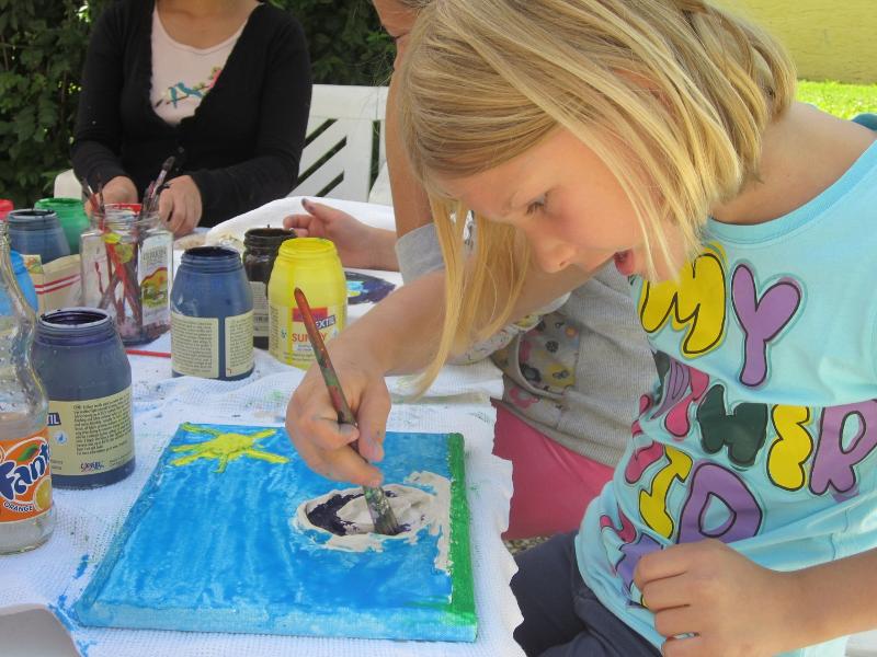 Mädchen malt ein Bild im im Sommercamp für Kinder