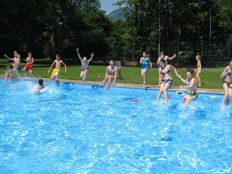 Die Teilnehmer der Ferienbetreuung Graz springen mit voller Freude in einen Pool