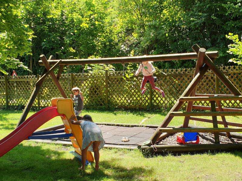 Kinder schaukeln im Sommercamp für Kinder