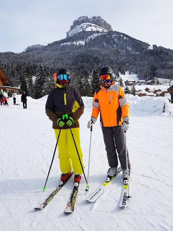 Zwei Skifahrer der Juvigo Skilager posieren vor einem Berg