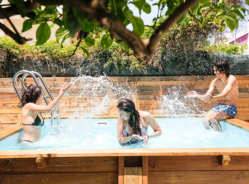 Jugendliche im Surf-Camp Portugal bespritzen sich im Pool mit Wasser 
