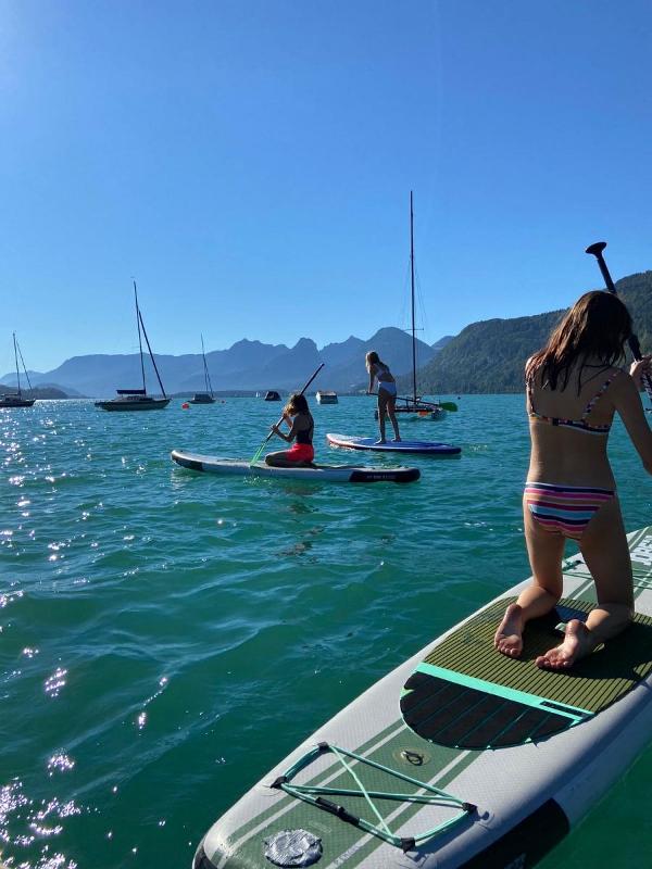 Mädchen paddeln auf See im Englischcamp Salzburg