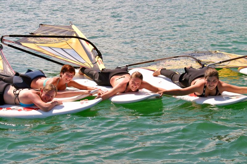 Mädchen liegen auf Surfbrettern im Ferienlager am See