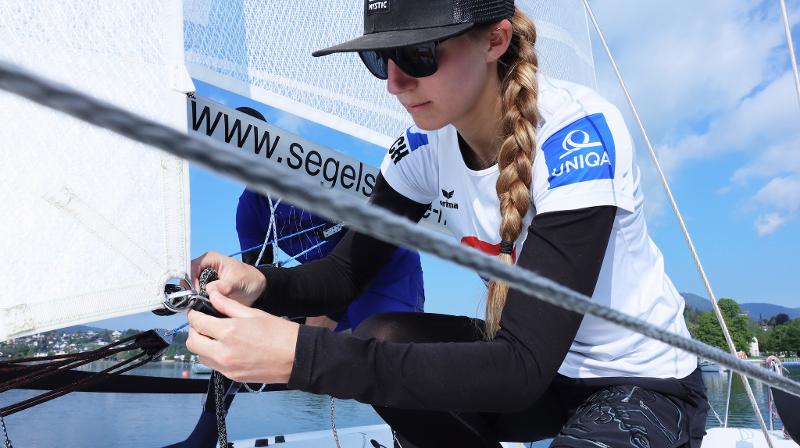 Mädchen macht Knoten im Ferienlager am See