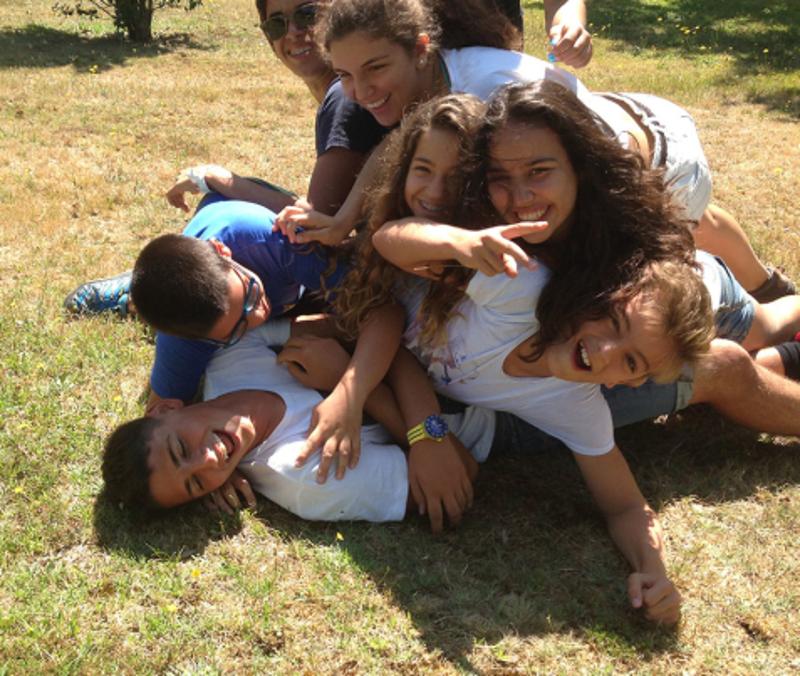 Kinder liegen aufeinander im Camp in Portugal