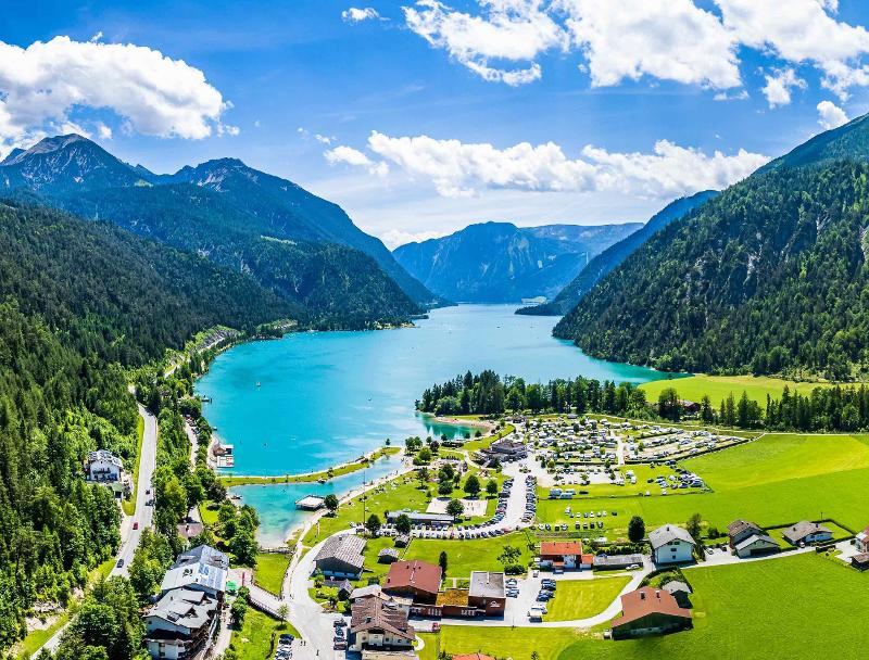 Blick von oben auf den türkisblauen Achensee umgeben von Bergen