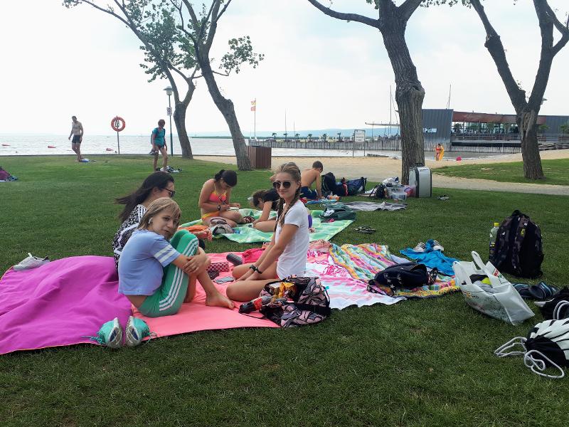 Teilnehmer sitzen am See im Feriencamp Wien