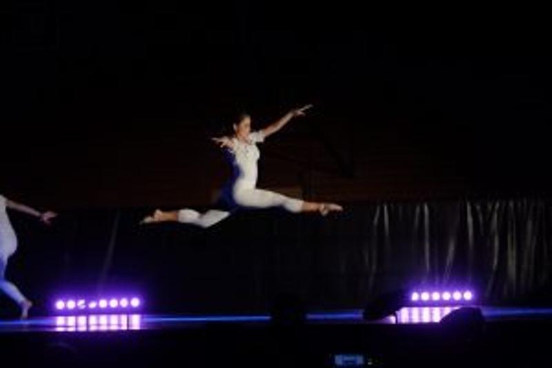 Im Sprachcamp macht ein Mädchen im Sprung einen Spagat beim Ballett