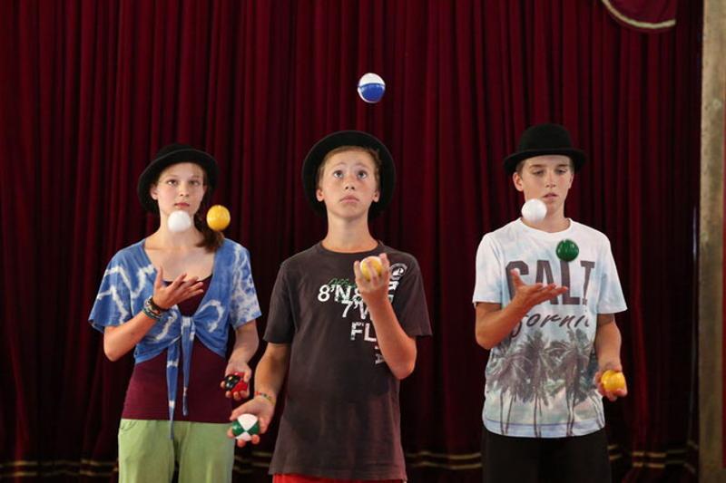Drei Kinder jonglieren zusammen im Zirkuscamp Drosendorf