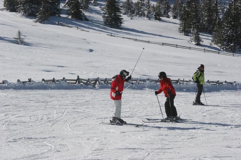 Zwei Kinder stehen sich mit Skiern gegenüber auf der Piste