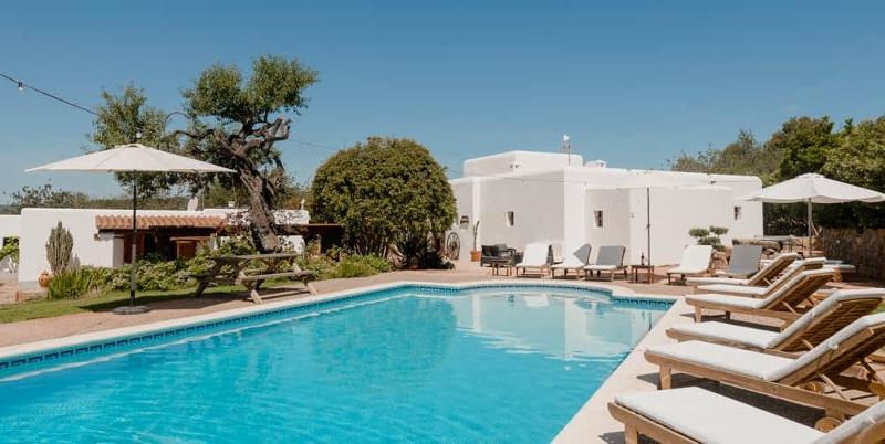 Privater Pool mit glasklarem Wasser und weißer Villa im Hintergrund