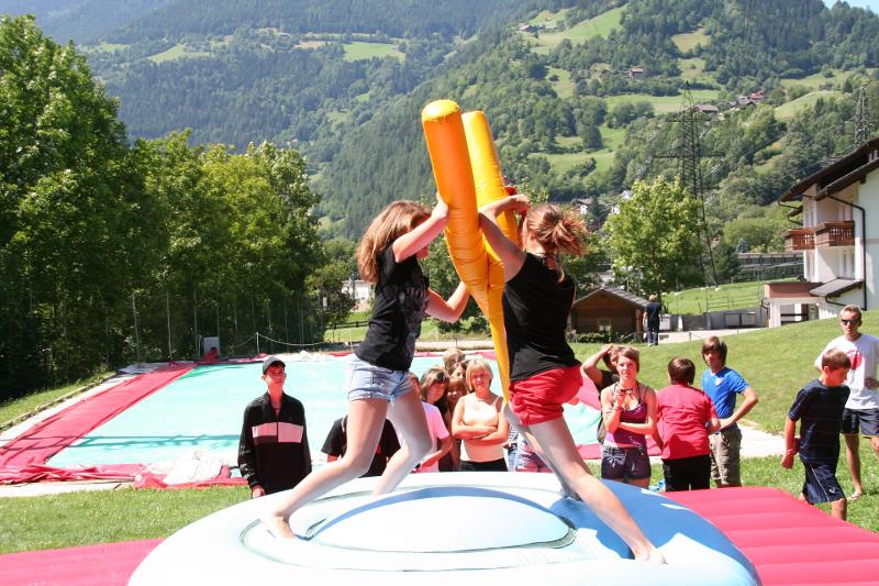 Zwei Mädchen kämpfen im Actioncamp spielerisch gegeneinander auf einem Luftkissen