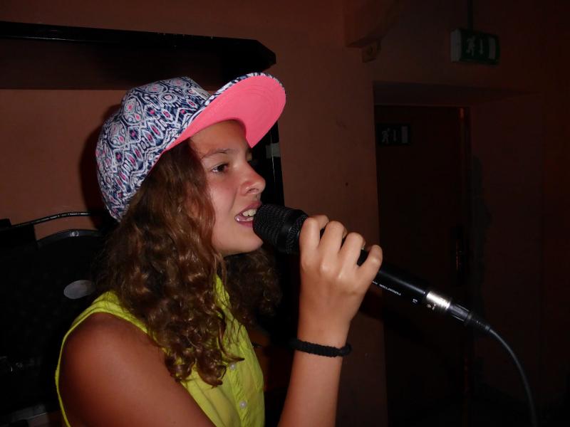 Ein Mädchen singt beim Karaokeabend während dem Sommercamp