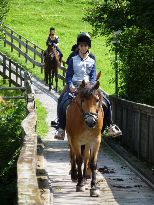 Mädchen reitet auf einem Pferd im Sommercamp
