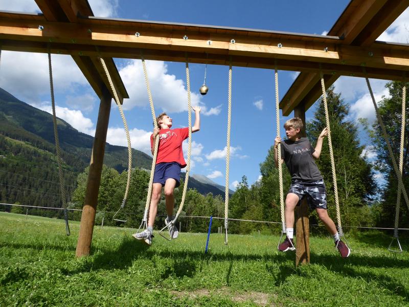 Zwei Jungs hangeln sich an Seilen in einem Sommercamp