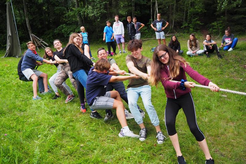 Im Actioncamp treten die Teilnehmer im Tauziehen gegeneinander auf einer Wiese an