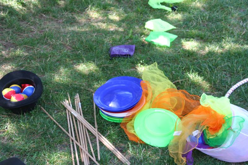 Auf der Wiese liegen bunte Bälle und Teller während des Zirkuscamps