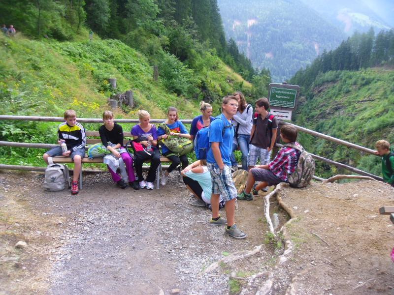 Die Teilnehmer des Englisch-Camps wandern durch den Wald und machen eine Pause an einer Bank