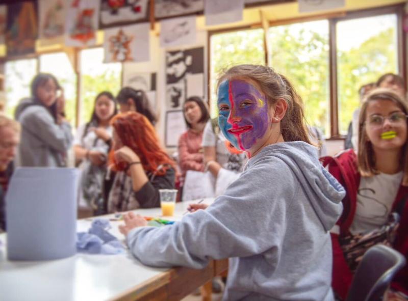 Mädchen schminkt ihr Gesicht in blau und lila während einer Sprachreise Dublin