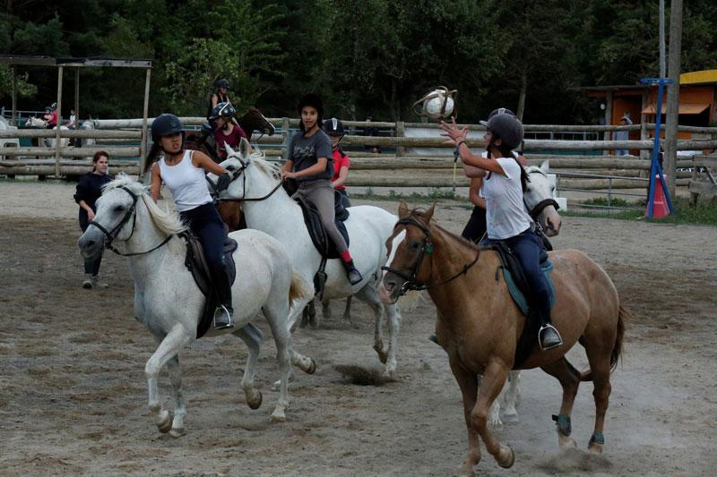 Kinder spielen Ball und reiten dabei bei den Reitcamps Steiermark
