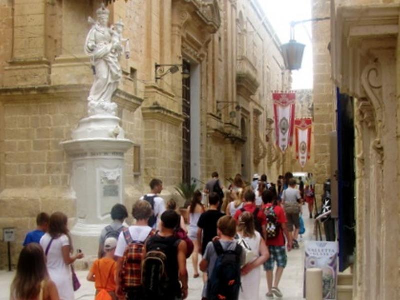 Die Teilnehmer der Sprachreise Valletta laufen während einer Stadtführung durch enge Gassen