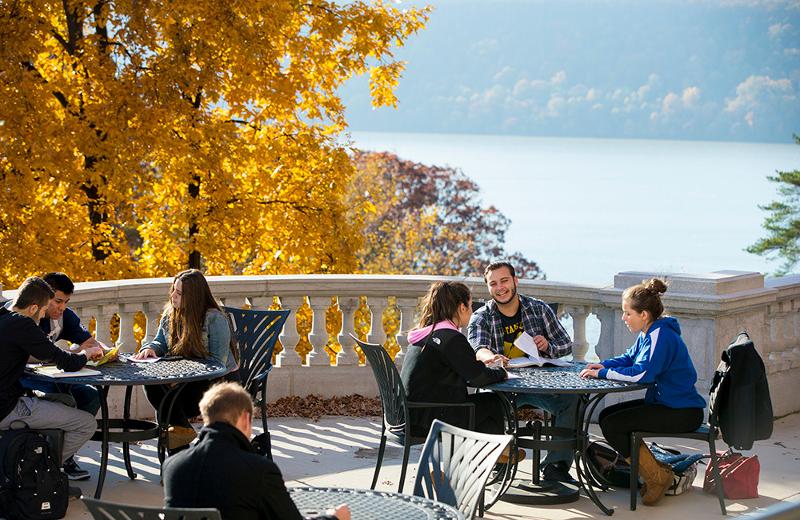 Un groupe d'étudiants est assis à une table dans le jardin pendant leur séjour linguistique New York et rit