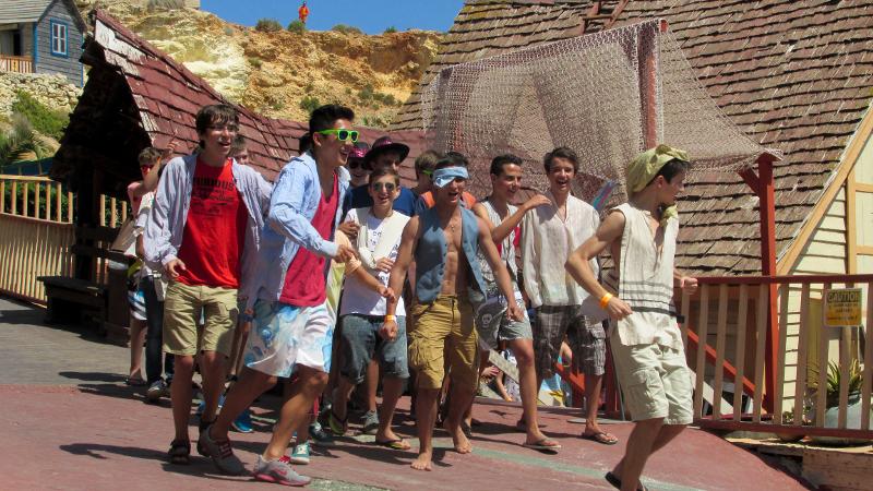 Eine Gruppe von Jugendlichen rennt im Sprachcamp Malta aus der Unterkunft