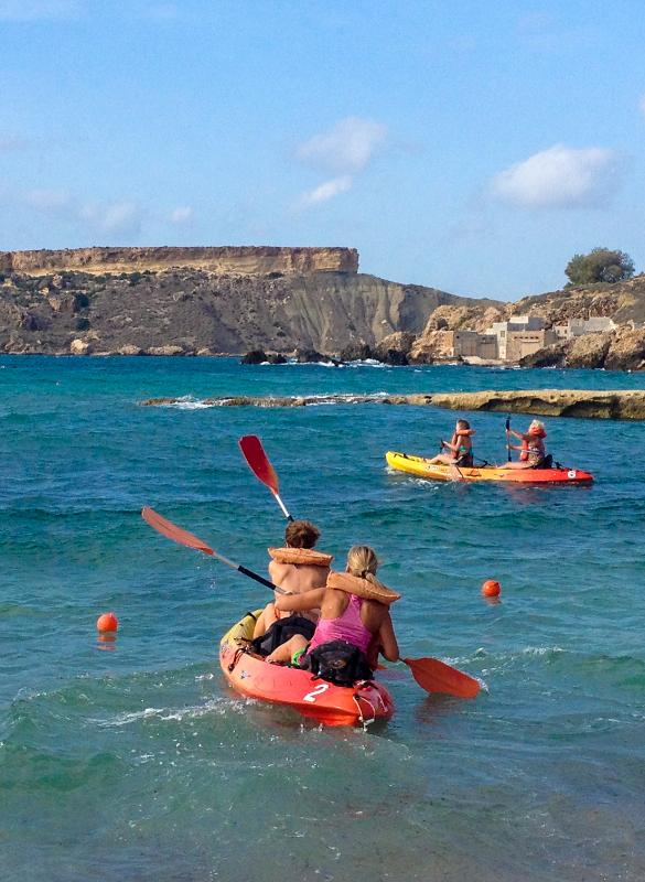 Mehrere Teilnehmer der Sprachreise Malta fahren Kanu im Meer