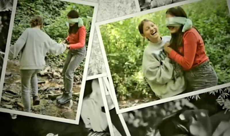 Mädchen mit verbundenen Augen wird von einem anderem Mädchen in der Kinderbetreuung Sommerferien durch den Wald geführt