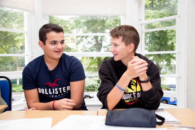 Zwei Jungen sitzen im Klassenzimmer und unterhalten sich