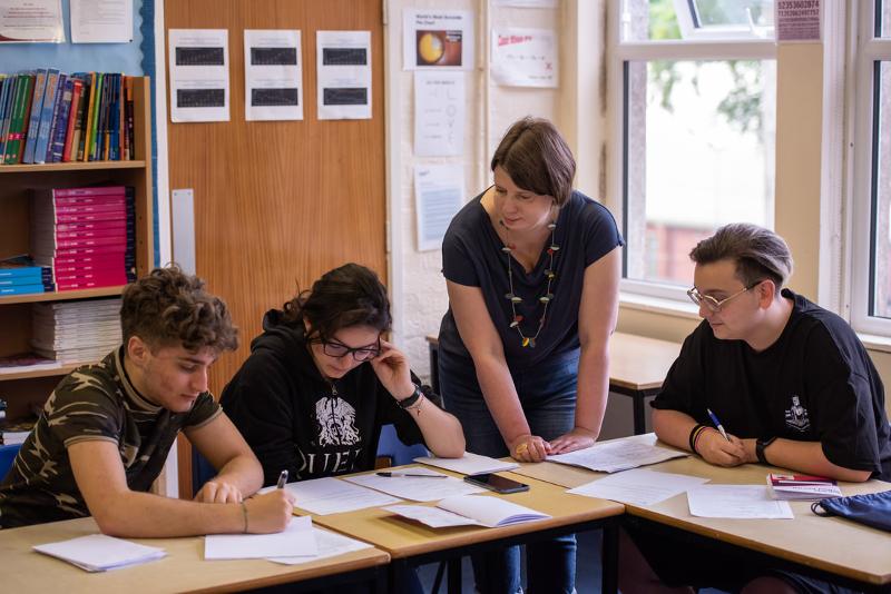 Auf der Schottland Sprachreise erklärt die Lehrerin den Schüler im Unterricht die Englisch-Aufgaben