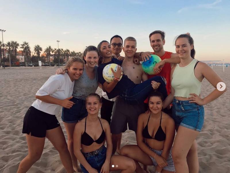 Eine Gruppe Jugendliche hat Spaß am Strand nach dem Volleyball spielen