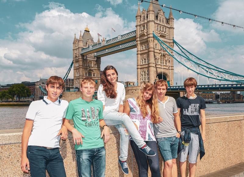 Teilnehmer einer Sprachreise stehen vor der Tower Bridge in London bei Sonnenschein