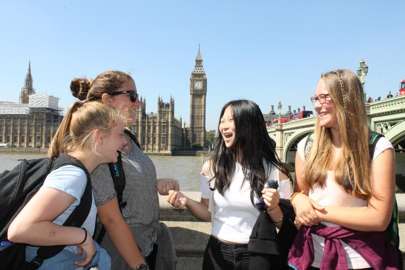 Vier Mädchen stehen vor dem Big Ben bei und lachen bei den Sprachreisen Cambridge