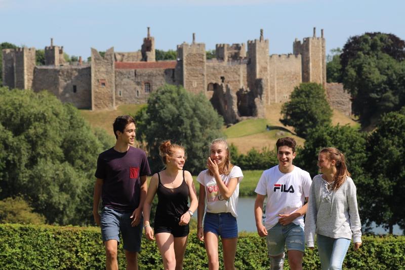 Jugendliche unterhalten sich und laufen von einem Schloss weg bei den Sprachreisen England Gastfamilie