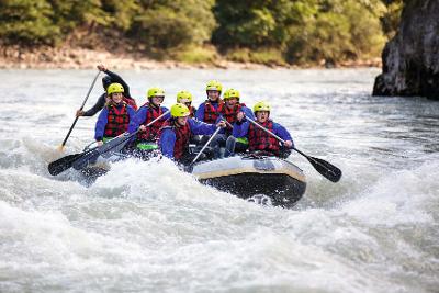 Spass mit Gummiboot auf dem Fluss im Abenteuerurlaub Kinder